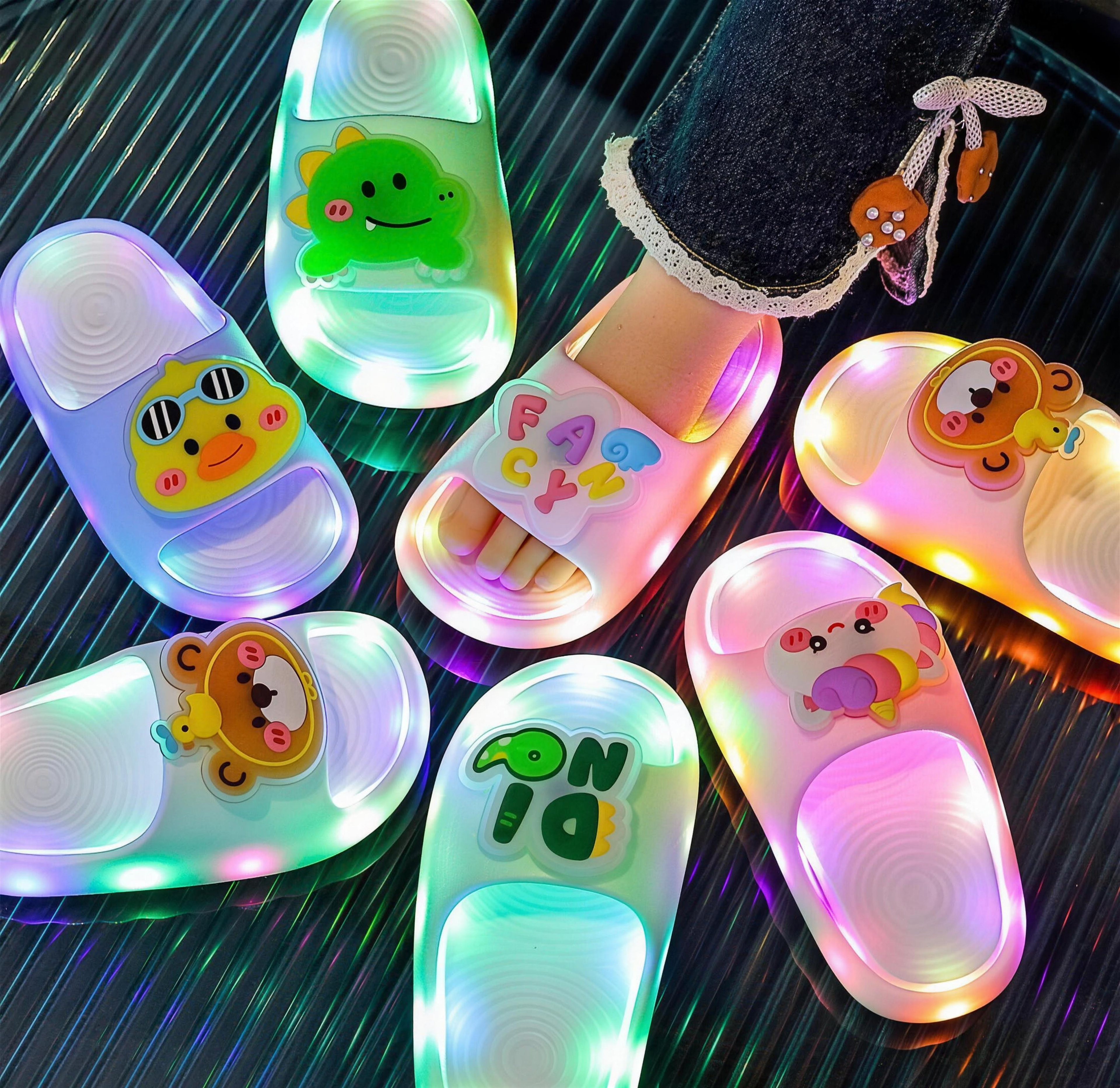 Seven STEPGLO slides in every design laid out together on a dark surface, each LED ring lit in a different colour, one pair worn