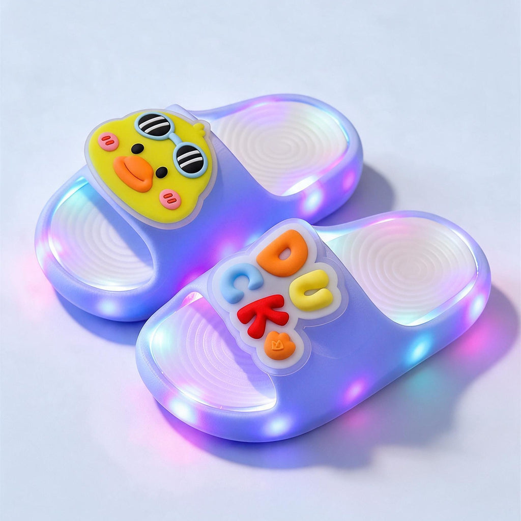 A pair of sky blue Duck STEPGLO slides, one strap with a duck in sunglasses and the other with DUCK in raised letters, LEDs lit around both soles.